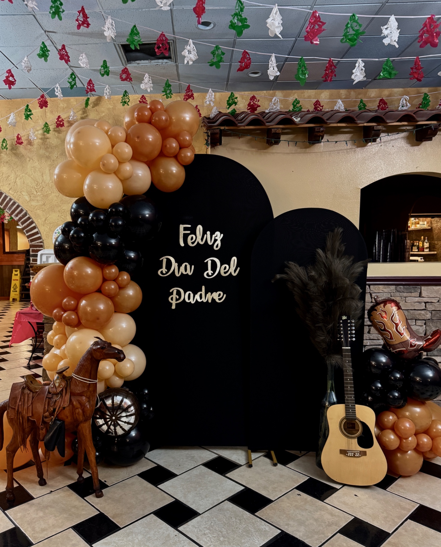 Black, tan and brown balloon garland on a black arch for Father's Day