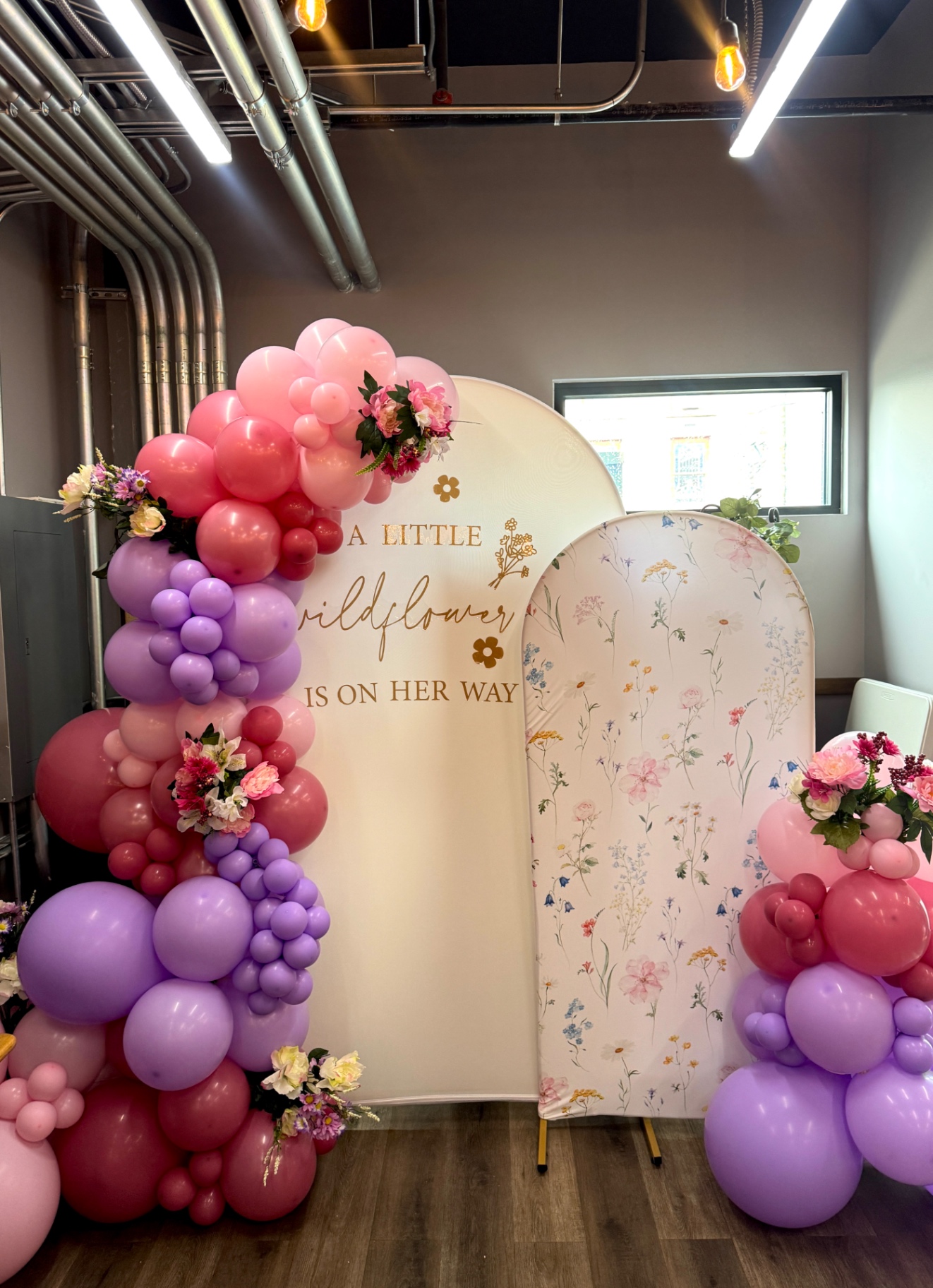 Pink and lavender balloon garland with floral arch for a baby shower