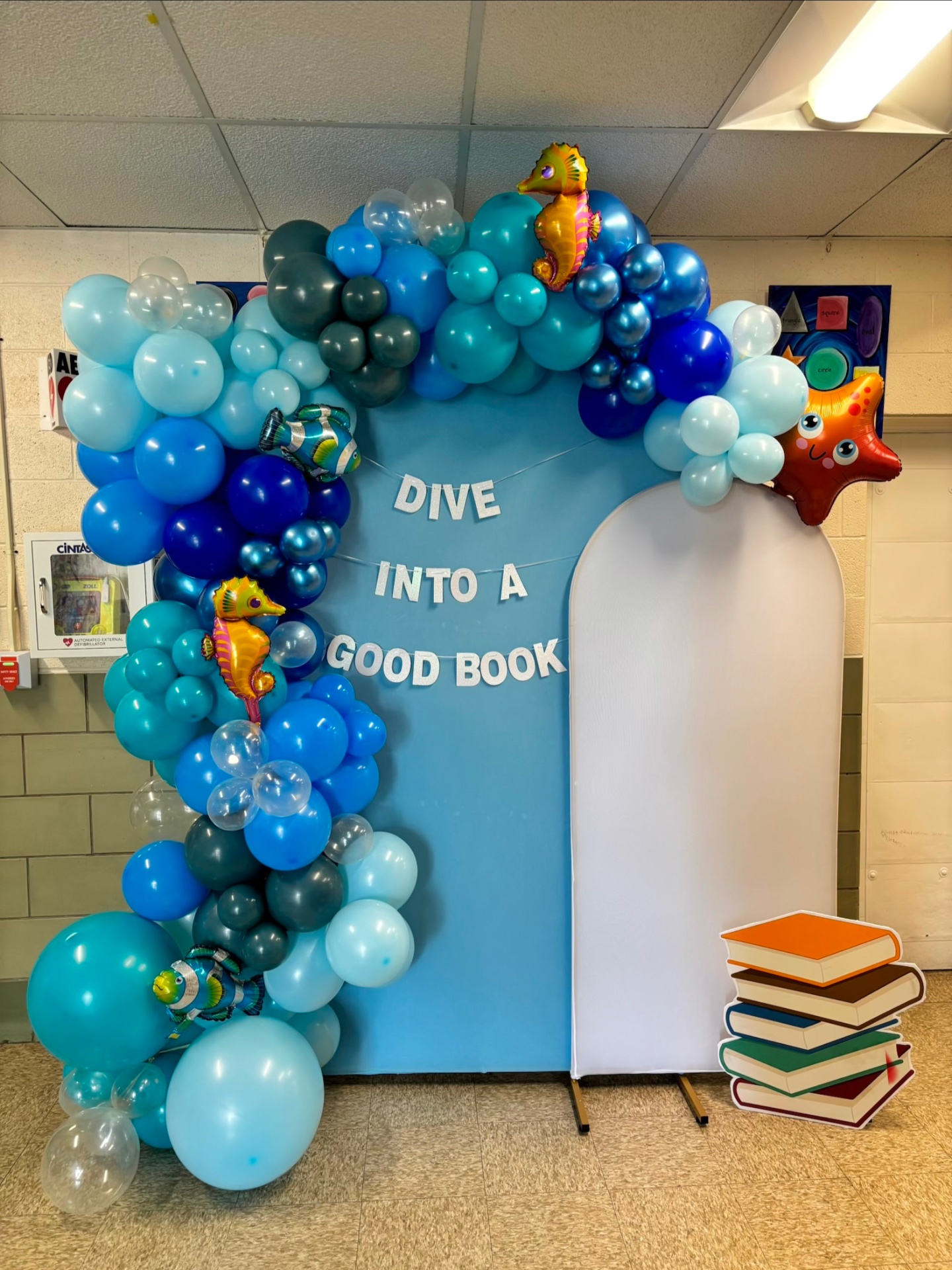 Blue school event balloon installation with under-the-sea reading theme